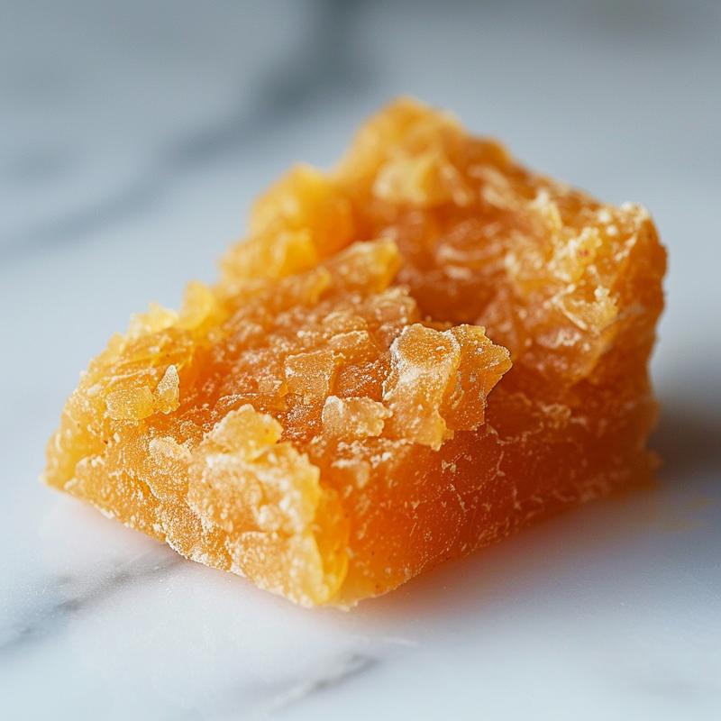 Close-up of smooth stage one baby food in a minimalist setting on white marble.